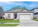 Charming single-story home featuring a two-car garage, well-manicured lawn, and a classic, inviting purple front door at 13469 Leaping Water Way, Astatula, FL 34705