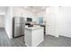 Bright kitchen featuring a center island, stainless steel appliances and grey wood floors at 13469 Leaping Water Way, Astatula, FL 34705
