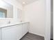 Bright bathroom featuring double sinks, a large mirror, and sleek wood-look flooring at 13465 Leaping Water Way, Astatula, FL 34705