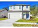 Charming two-story home with a well-manicured lawn, two-car garage, and inviting blue front door at 13465 Leaping Water Way, Astatula, FL 34705