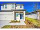 Inviting entrance to this charming home showcasing a bright blue door and modern landscaping at 13465 Leaping Water Way, Astatula, FL 34705