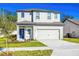 Charming two-story home featuring a two car garage, blue front door, and well maintained lawn at 13485 Leaping Water Way, Astatula, FL 34705