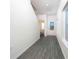 Hallway featuring wood floors, white walls, leading to the front door and half-bathroom at 13485 Leaping Water Way, Astatula, FL 34705