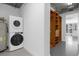 Laundry closet with a stacked washer and dryer, with open shelving leading into the apartment at 150 E Robinson St # 221, Orlando, FL 32801