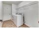 Bright laundry room with washer, dryer, and overhead shelving at 2804 Polson Dr, Kissimmee, FL 34758