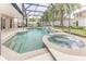 Inviting pool and spa with waterfall feature, screened enclosure, and ample deck space at 2804 Polson Dr, Kissimmee, FL 34758