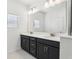 Bathroom with double vanity, modern lighting, and a large mirror at 520 Astera Winds Ln, Lake Mary, FL 32746