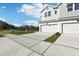 Townhome exterior showcasing the concrete driveway, green grass, and gray siding at 520 Astera Winds Ln, Lake Mary, FL 32746