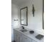 Bathroom featuring double vanity with marble countertop, gold framed mirror, modern faucet, and artful light fixture at 13467 Panama Beach Ct, Orlando, FL 32827