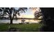 Scenic waterfront view with a private dock at sunset at 509 E Lakeshore Dr, Ocoee, FL 34761