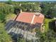 Aerial view of the house with a red tile roof and screened-in pool at 2024 Capri Ln, Mount Dora, FL 32757
