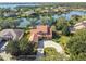 Aerial view of the house overlooking the lake, landscaping, and circular driveway at 2024 Capri Ln, Mount Dora, FL 32757