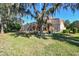 A view of the house from the backyard shows the screened lanai and mature trees at 2024 Capri Ln, Mount Dora, FL 32757