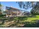 The backyard of this home has a screened lanai and overlooks a manicured green lawn at 2024 Capri Ln, Mount Dora, FL 32757