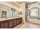 This spacious bathroom has a large vanity with double sinks, large tub, and glass door shower at 2024 Capri Ln, Mount Dora, FL 32757