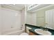 Bright bathroom featuring a shower-tub combo with white tiling and a green countertop vanity at 2024 Capri Ln, Mount Dora, FL 32757