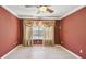 A bedroom painted in shades of red offers hardwood flooring and curtains over a window at 2024 Capri Ln, Mount Dora, FL 32757