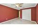 Red bedroom featuring wood floors, closet, and crown molding, offering a modern touch at 2024 Capri Ln, Mount Dora, FL 32757