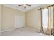 Cozy carpeted bedroom featuring a ceiling fan, window with curtains, and closet at 2024 Capri Ln, Mount Dora, FL 32757