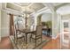 Elegant dining room with a chandelier, coffered ceilings, and a large window overlooking a tropical view at 2024 Capri Ln, Mount Dora, FL 32757