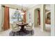 Cozy dining room featuring a round wood table and decorative chandelier with scenic backyard views at 2024 Capri Ln, Mount Dora, FL 32757