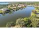 Aerial view of a picturesque lake surrounded by houses and lush greenery at 2024 Capri Ln, Mount Dora, FL 32757