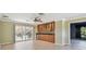 Living room featuring hardwood flooring, bar with cabinets, sliding doors to the lanai, and mini fridge at 2024 Capri Ln, Mount Dora, FL 32757