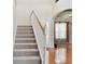 Carpeted staircase with wooden handrail and view of hardwood floors and living area at 2024 Capri Ln, Mount Dora, FL 32757