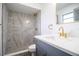 Renovated bathroom with gray tile shower and gold accents at 7631 Lewis Rd, Lakeland, FL 33810