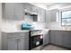 Updated kitchen featuring gray cabinets and a marble backsplash at 7631 Lewis Rd, Lakeland, FL 33810