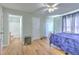 Bedroom featuring two doors, a ceiling fan, wood flooring, a bed, and a glimpse into the en-suite bathroom at 169 Vista View Ave, Eagle Lake, FL 33839