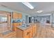 Open kitchen layout with an island, wood cabinetry, granite countertops, and a view of the dining area at 169 Vista View Ave, Eagle Lake, FL 33839