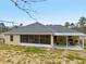 Aerial view of the home's back exterior with enclosed and open patios, with chain link fence and spacious yard at 769 Marion Oaks Manor, Ocala, FL 34473