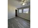 This bedroom features neutral walls, wood-look flooring, a ceiling fan and two windows at 1224 10Th St, Holly Hill, FL 32117
