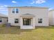Backyard view of a home with a covered patio and ample grass space at 4430 Petunia St, Lake Hamilton, FL 33851