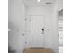 Clean entryway with tiled floor, white walls, and white doors showcasing a minimalist design at 4430 Petunia St, Lake Hamilton, FL 33851