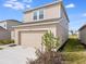 Two-story home with tan siding and an attached garage at 4430 Petunia St, Lake Hamilton, FL 33851