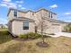 Two-story home with tan siding, green shrubs and manicured lawn at 4430 Petunia St, Lake Hamilton, FL 33851