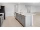Open-concept kitchen with stainless steel appliances, gray cabinetry, and center island with sink at 4430 Petunia St, Lake Hamilton, FL 33851