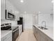 Modern kitchen with stainless steel appliances, sleek gray cabinets, and a large island with a sink at 4430 Petunia St, Lake Hamilton, FL 33851