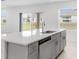 Bright kitchen island with a stainless steel sink and dishwasher, overlooking the backyard through a window at 4430 Petunia St, Lake Hamilton, FL 33851