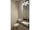 Bathroom with granite countertop and sink, vanity with storage, commode, and modern lighting at 17729 Se 114Th Ct, Summerfield, FL 34491