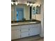 Bathroom featuring double sinks, granite countertops, modern lighting, and updated cabinetry at 17729 Se 114Th Ct, Summerfield, FL 34491