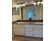 Bathroom featuring double sinks, granite countertops, modern lighting, and updated cabinetry at 17729 Se 114Th Ct, Summerfield, FL 34491