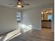 Bedroom featuring wood floors, a ceiling fan, a large window, and an adjacent bathroom at 17729 Se 114Th Ct, Summerfield, FL 34491