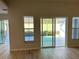 Bright living room featuring wood floors, large windows, and sliding door access to an outdoor space at 17729 Se 114Th Ct, Summerfield, FL 34491