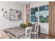 Dining area with a rustic wood table, white chairs, and a modern light fixture at 4464 Sw 84Th Street Rd, Ocala, FL 34476