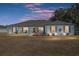 Dusk view of a well-kept single-story home with covered front porch seating at 3805 Sw 115Th St, Ocala, FL 34476