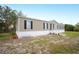 Tan single-wide manufactured home with black shutters and landscaping at 3046 Crystal Hills Dr, Lakeland, FL 33801
