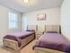 Two twin beds with purple covers in a well-lit bedroom at 3052 Cassidy Ln, Haines City, FL 33844